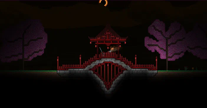 Dans le jeu Terraria, un personnage se tient sur une plateforme en bois rouge ornée de balustrades devant des arbres à feuilles violettes sous un ciel nocturne.