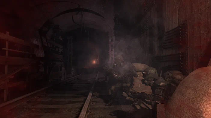 Dans le jeu vidéo Metro 2033, deux personnages en armure se tiennent dans un tunnel sombre et fumant avec des rails de train.