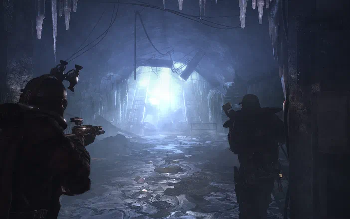 Dans le jeu vidéo Metro 2033, deux personnages armés se tiennent dans un tunnel de métro sombre et glacé avec des stalactites.