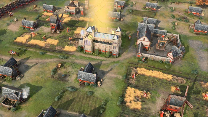 Vue aérienne d'un village médiéval dans Age of Empires IV avec des fermes, une église et des soldats.