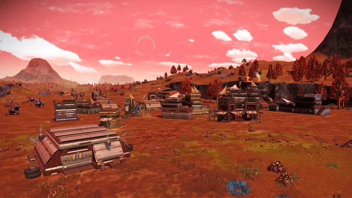 Vue d'une colonie dans le jeu vidéo No Man's Sky sous un ciel rose avec des structures et arbres rouges