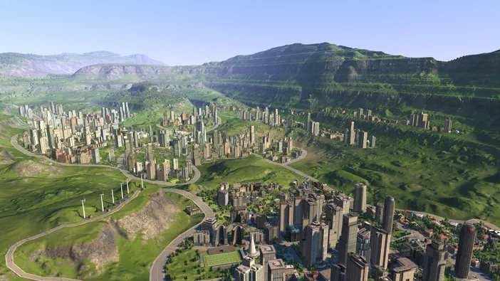 Capture d'écran du jeu Cities XL Platinum montrant une ville dense construite dans un paysage vallonné avec des montagnes en arrière-plan.