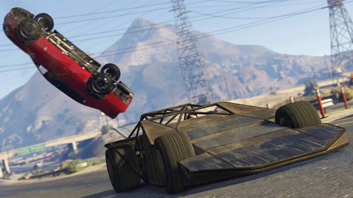 Grand Theft Auto V Legacy : une voiture rouge en l'air et un véhicule de course renversé sur une route avec des montagnes à l'arrière-plan.